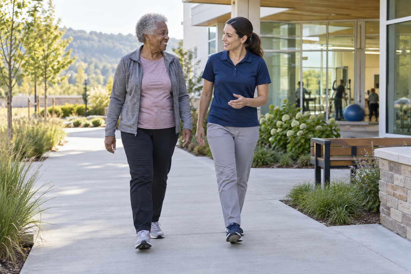 Older adult walking beside a practitioner on a level path