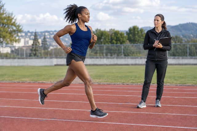 Une praticienne observe une coureuse sur une piste